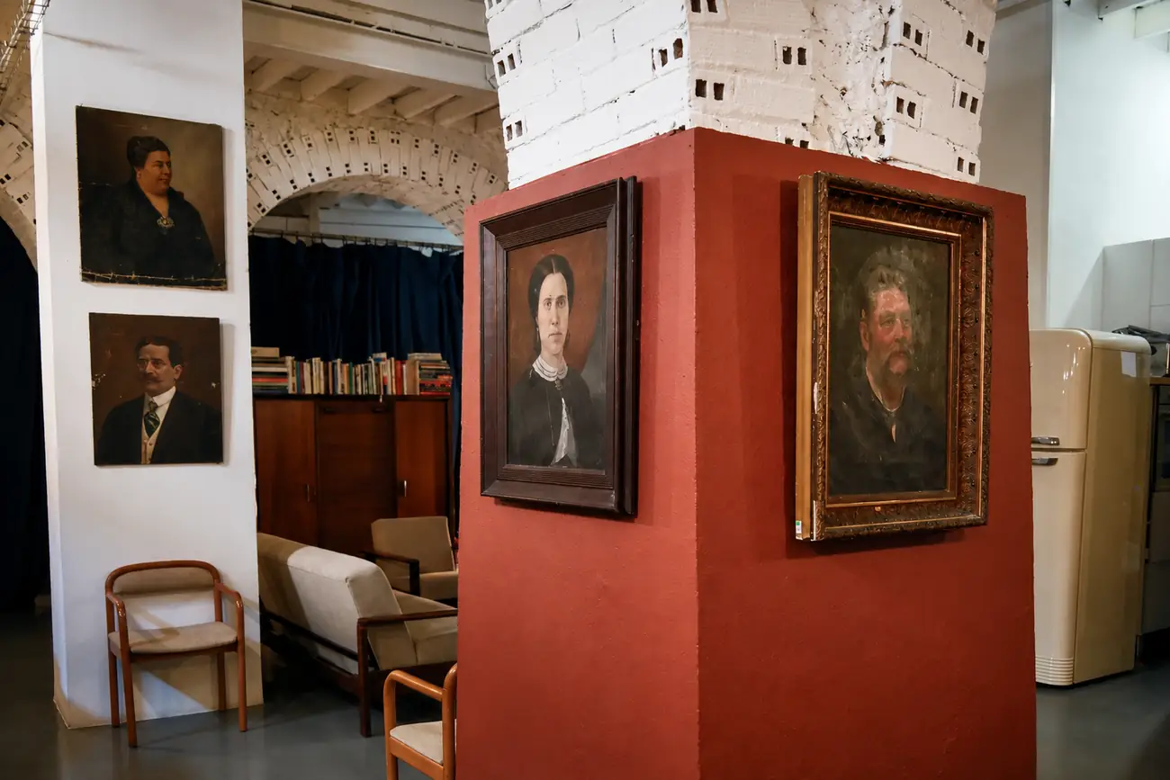 Vários ambientes da sala vistos ao mesmo tempo, com o bloco de tijolo ao centro.