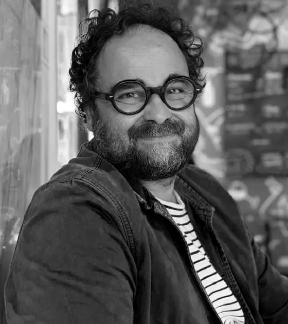 Retrato a preto e branco do chef Leopoldo Calhau, de óculos redondos e barba.
