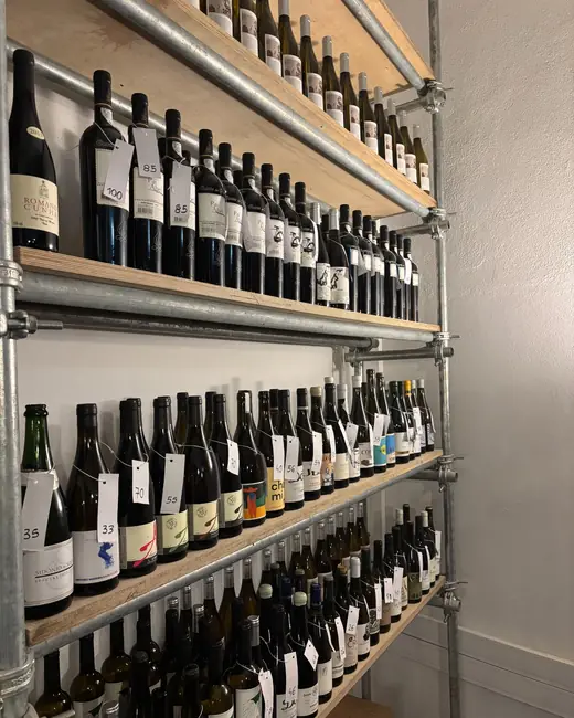 Estantes com dezenas de garrafas de vinho etiquetadas à mão, na garrafeira do Couvert Lisboa.