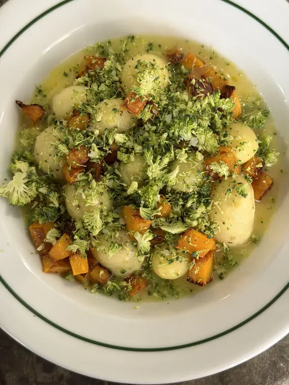 Travessa de batatas novas com molho verde de ervas e legumes assados.