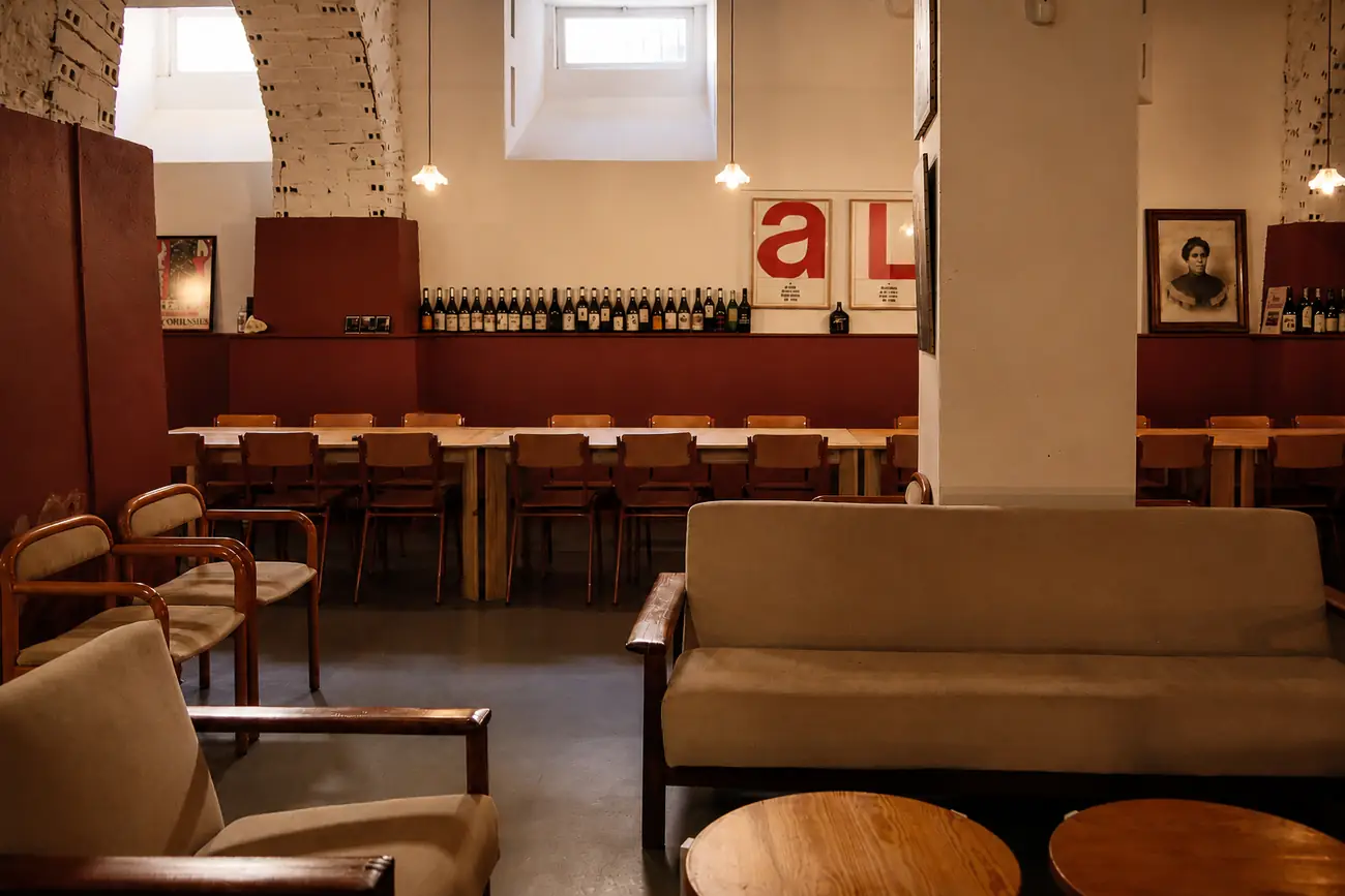 Vista geral da sala do Couvert Lisboa, com a zona de estar em primeiro plano e a mesa corrida ao fundo.